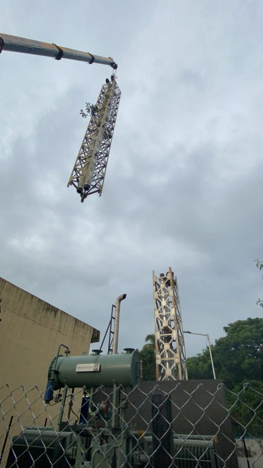 Crane lowering a twin-flue lattice section onto the standing stack base
