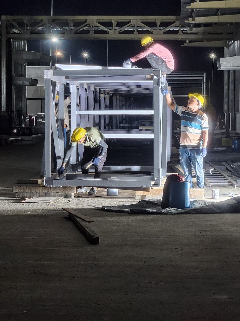 Night finishing work on a fabricated lattice stack section under floodlights